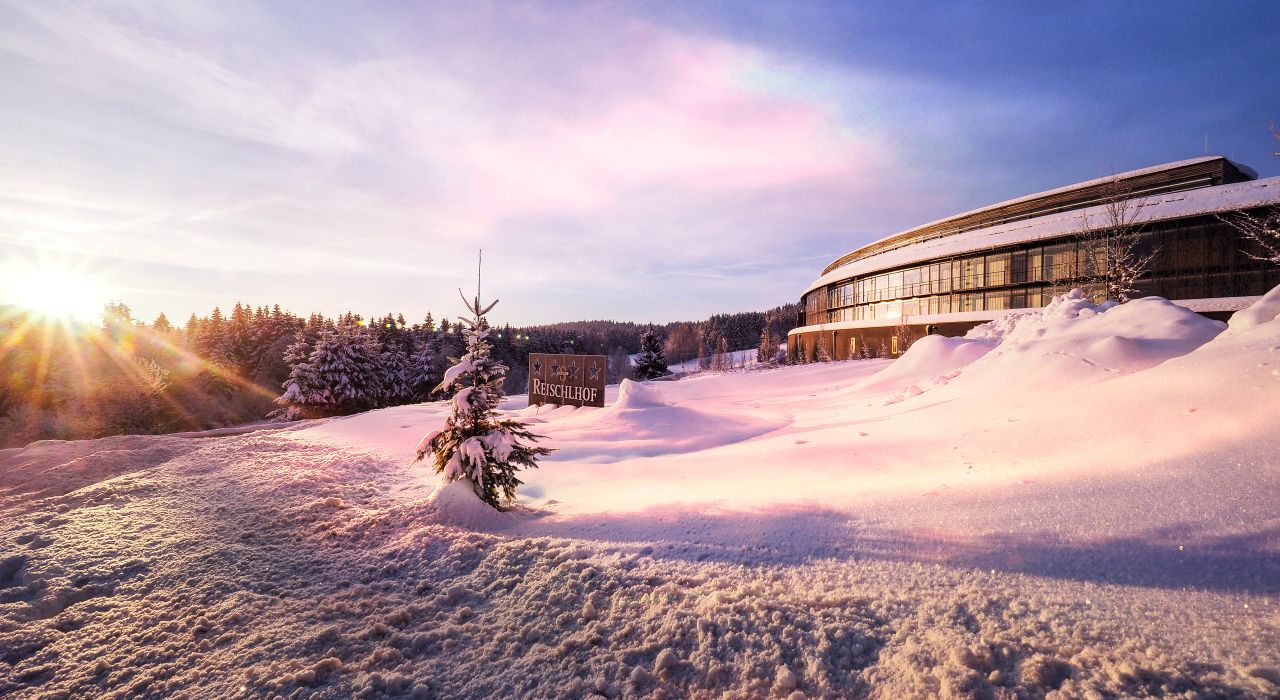 Winteransicht des Reischlhof von der Zufahrt aus bei Sonnenaufgang